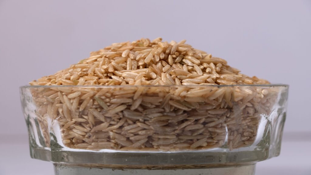 Raw brown rice in a clear glass bowl with nutty texture and fluffy grains