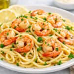 Easy lemon garlic shrimp pasta with fresh parsley and lemon served on a white plate