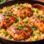 One pan honey garlic chicken and rice in a skillet topped with green onions
