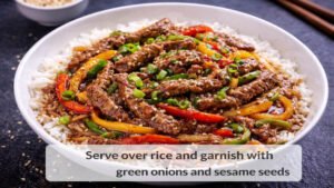 Beef and pepper stir fry served over rice in a bowl
