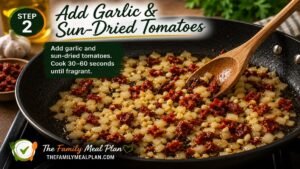 Garlic and sun-dried tomatoes cooking with softened onions in a skillet for Step 2 of Creamy Tuscan White Bean Skillet.